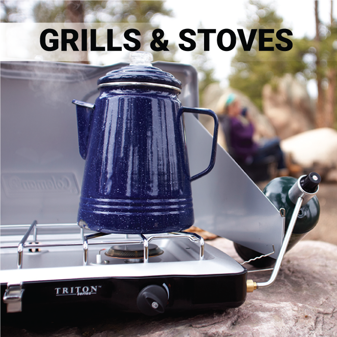 blue kettle sitting on Coleman Triton+ propane stoe in wilderness